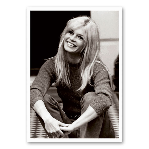 Zwart-wit foto van Brigitte Bardot met een stralende glimlach, straalt charme en vintage elegantie uit.